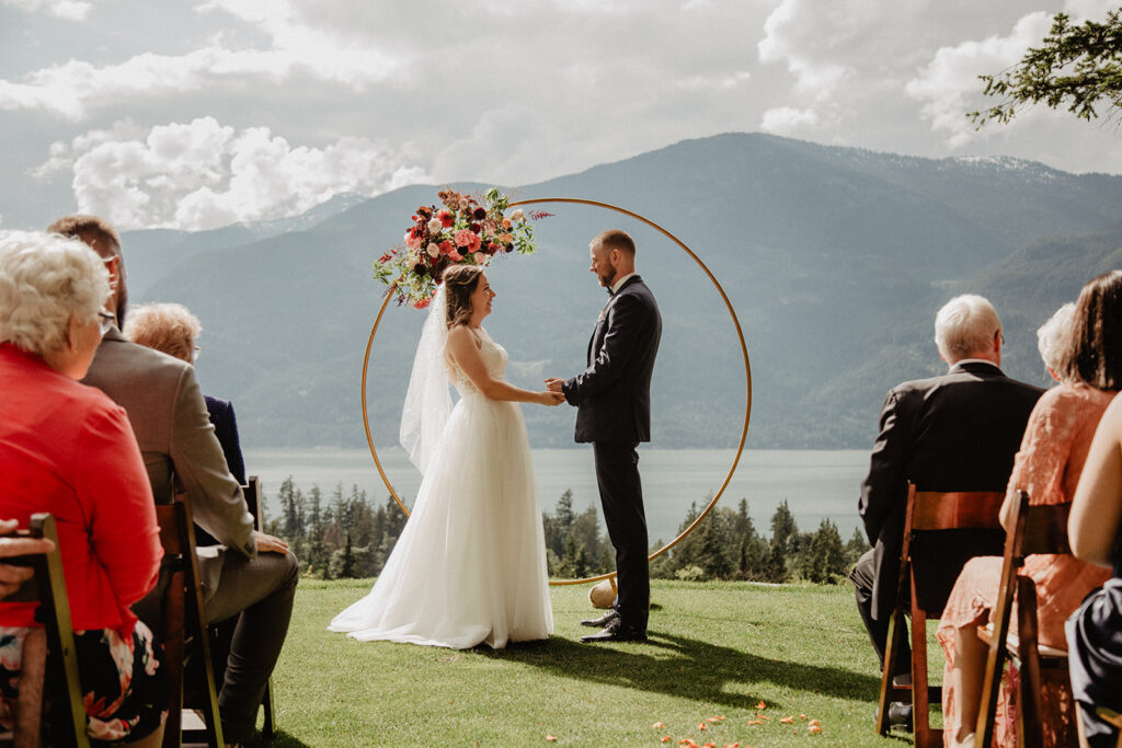 Couple holding hands during their wedding ceremony, at a mountain view BC wedding venue